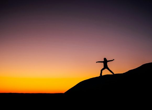 shillouette photo of person standing at the peak