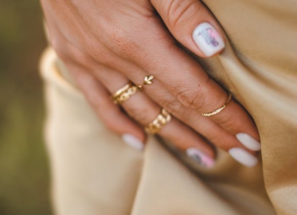 person wearing gold ring with blue stone